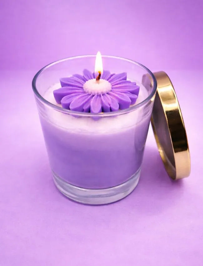 Purple candle in a glass jar with a gold lid on a purple background