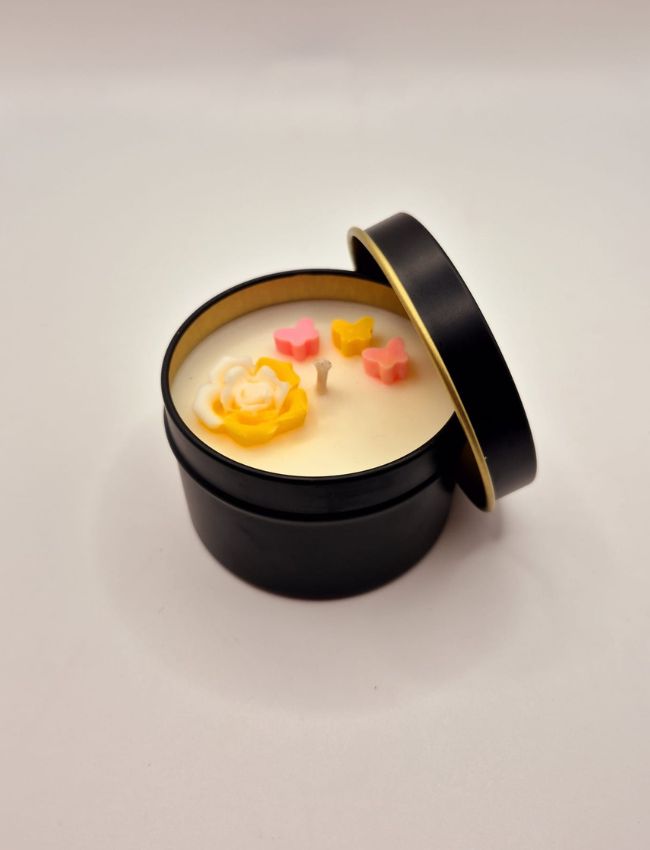 Soy candle in a dark tin with orange flower decorations and an invigorating citrus aroma.