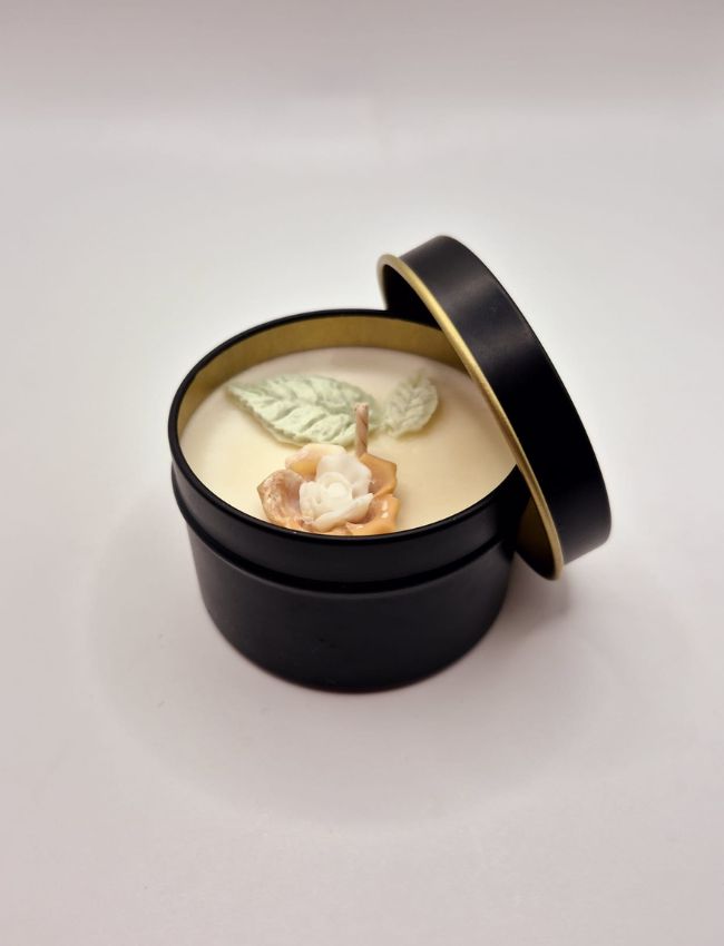 Golden Sunshine soy candle in a black tin with yellow flower decorations and a warm, sunny citrus scent.