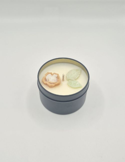 Golden Sunshine soy candle in a black tin with yellow flower decorations and a warm, sunny citrus scent.