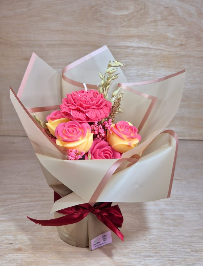 Decorative candle bouquet with pink, white, and teal wax flowers.