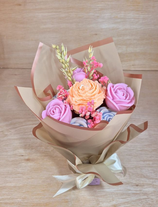 Pink and red heart-shaped wax candles arranged in bouquet style.