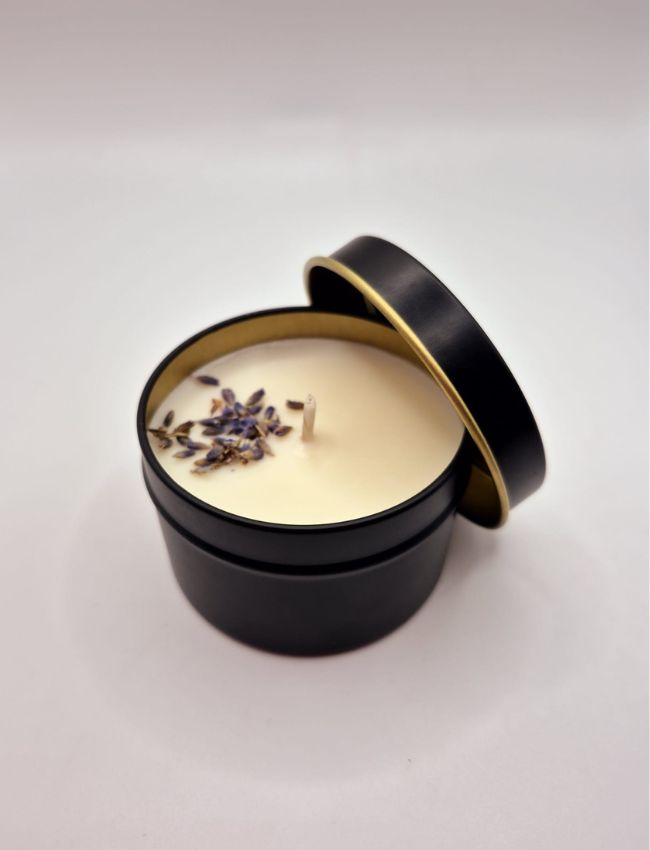 Soy candle in a black tin with lead, adorned with dried lavender and featuring a soothing herbal scent.