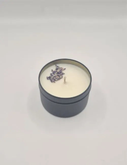 Soy candle in a silver tin, adorned with dried lavender and featuring a soothing herbal scent.