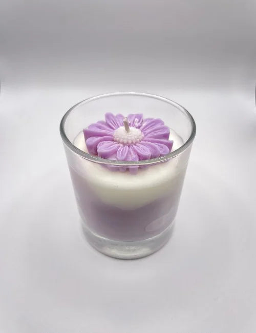 Lavender Dream soy candle with a purple and white layered design and a floral wax embellishment.