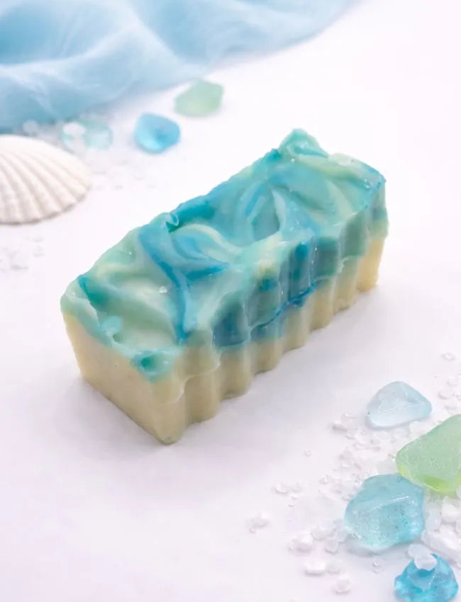Handcrafted soap with blue and green swirls on a white background