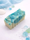 Handcrafted soap with blue and green swirls on a white background