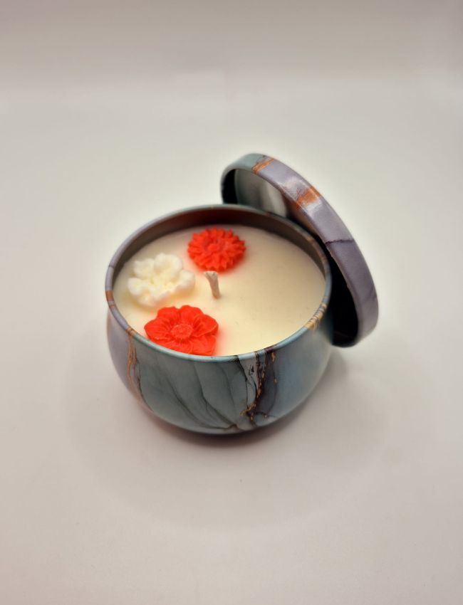 Soy candle in a light blue marbled tin adorned with rose-shaped wax decorations and a romantic rose scent.