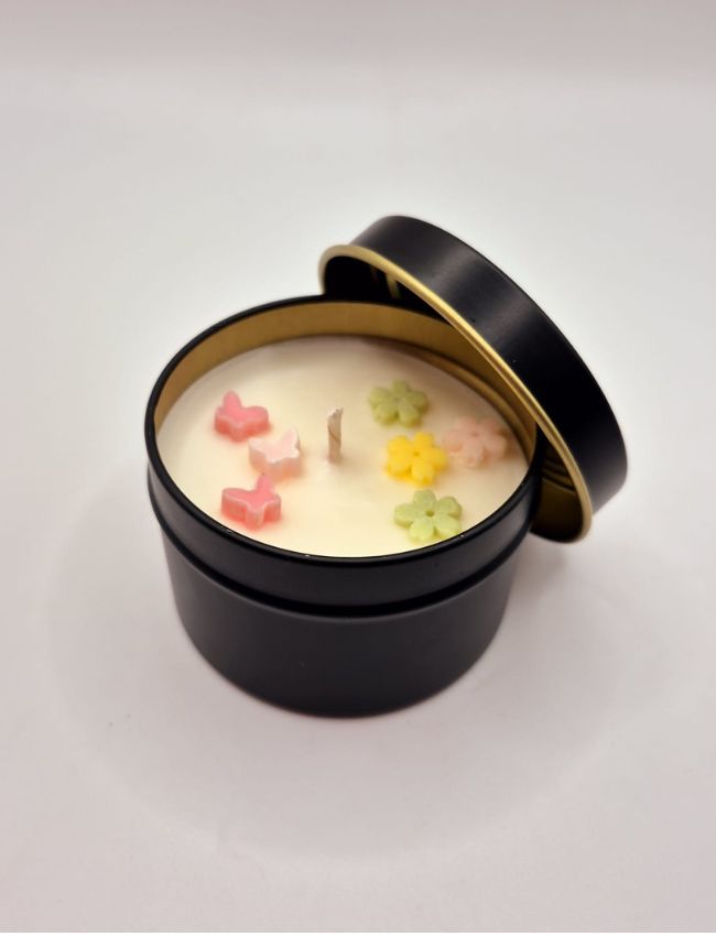 Spring Whimsy candle in black tin with floral decoration.