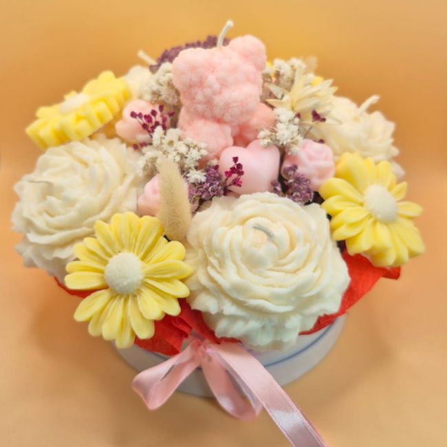 Floral soy wax candle arrangement in soft orange and lavender tones.