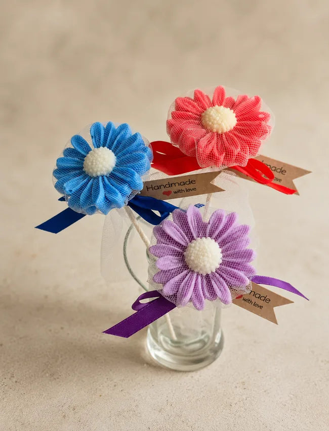 Assorted AuraBliss daisy flower candle gifts in blue, pink and lavender