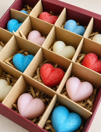 Close-up of colourful heart-shaped soy wax melts arranged in a burgundy gift box
