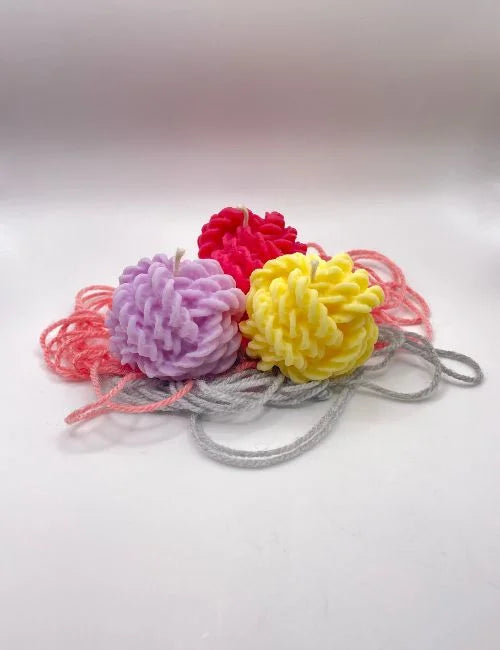 A group of Knitted Charm soy candles in lavender, red, and yellow, featuring intricate knitted patterns, perfect for decor and gifts.