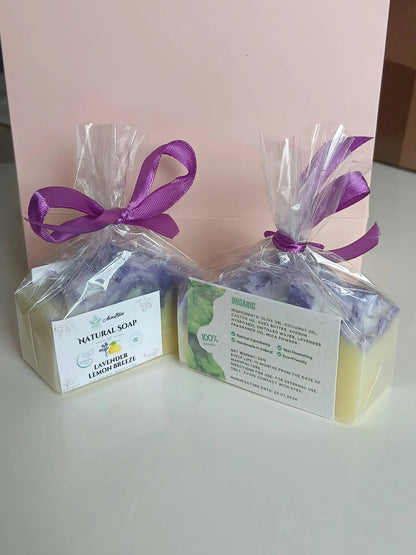 Two wrapped soap bars with purple ribbons showing the front and back labels