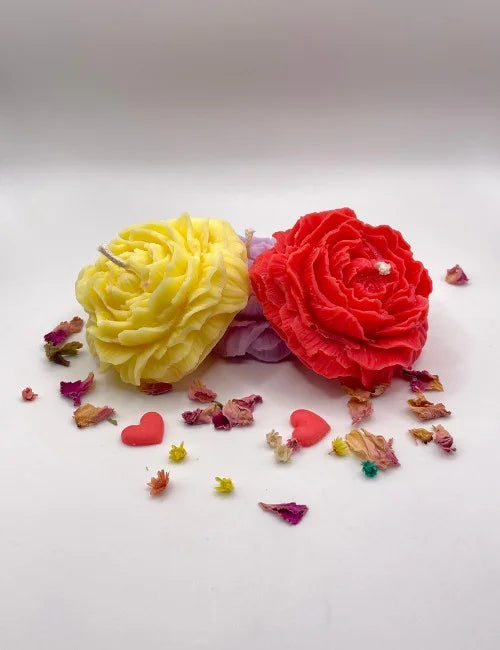 Natural candles in various colors, including yellow, purple, and red, all shaped like roses.