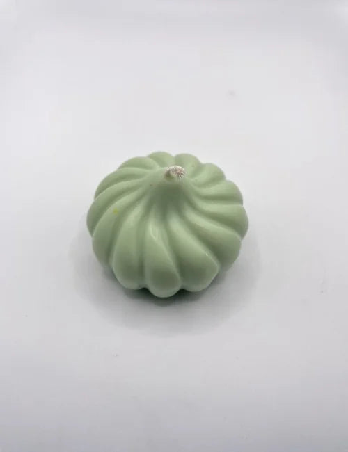 Pumpkin Charm candle in soft green, featuring a stylish swirled design, made from natural ingredients.