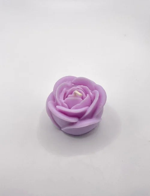 A lavender rose-shaped candle with intricate details, adding charm to romantic and cozy settings.
