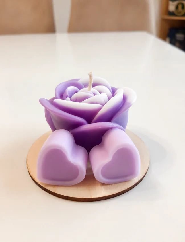 Purple rose candle with two purple heart wax melts on a round wooden base