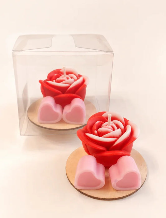 Red rose candle with two pink heart wax melts presented in a clear gift box on a wooden base