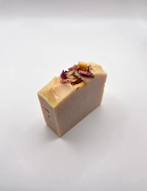 Soap bar infused with dried rose petals, designed for nourishing and natural skincare.