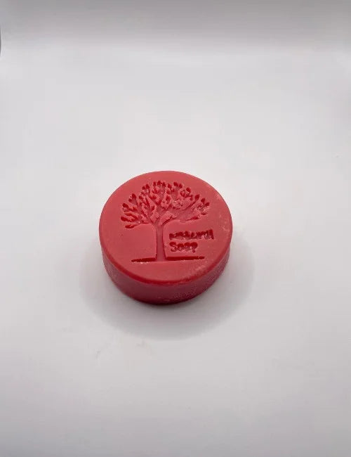 A red Simply Natural round soap with a tree stamp, ideal for refreshing and moisturizing skin naturally.