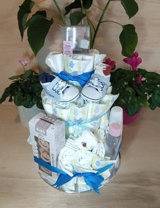A beautifully arranged diaper cake-style baby hamper, decorated with blue ribbons and filled with essential baby products.
