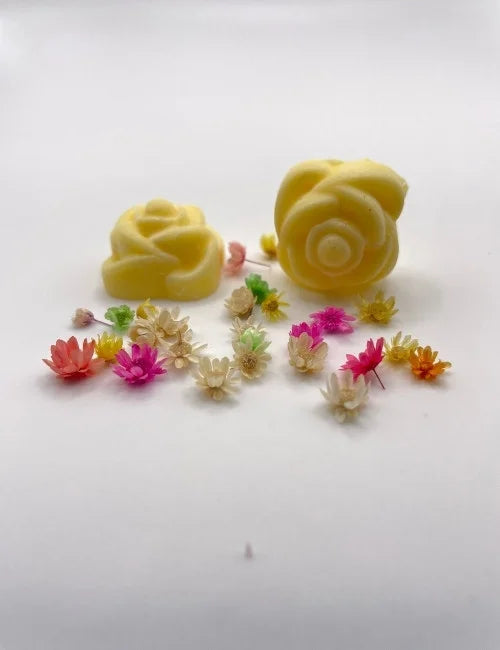 Yellow rose-shaped wax melts surrounded by colorful dried flowers.