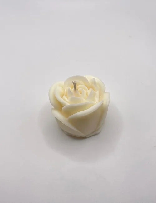 A delicate white rose-shaped candle, perfect for weddings, romantic dinners, and serene decor.